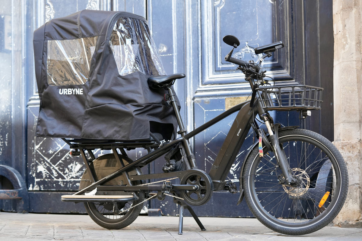 Housse de pluie Urbyne montée sur un vélo cargo longtail, vue latérale, Paris